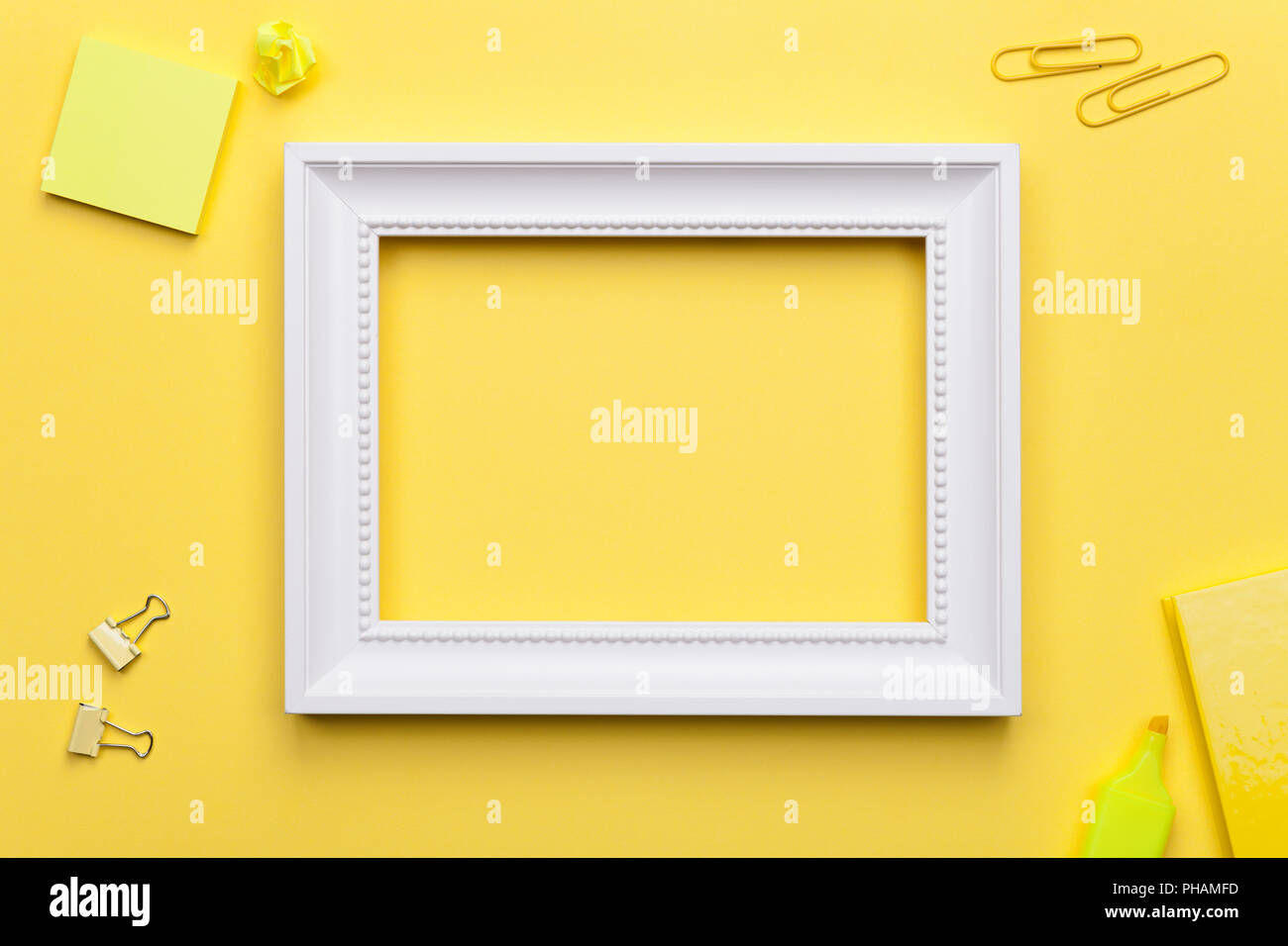 White Frame with Office Accessories on Yellow Background Stock Photo
