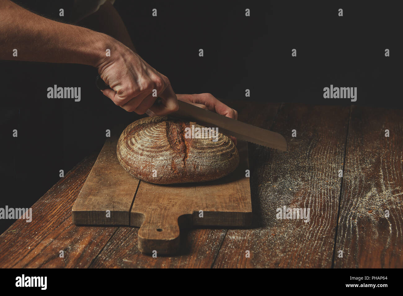 Men's hands cut bread Stock Photo