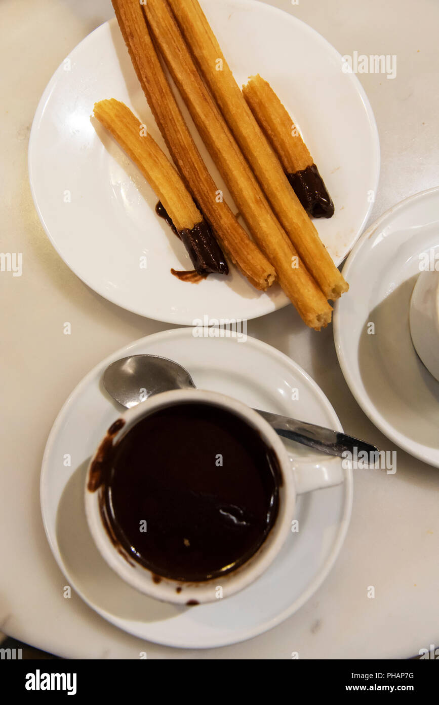 Hot chocolate and churros at Chocolateria San Gines. It is a cafe near Plaza Mayor that mainly serves chocolate con churros since 1894. Madrid, Spain Stock Photo