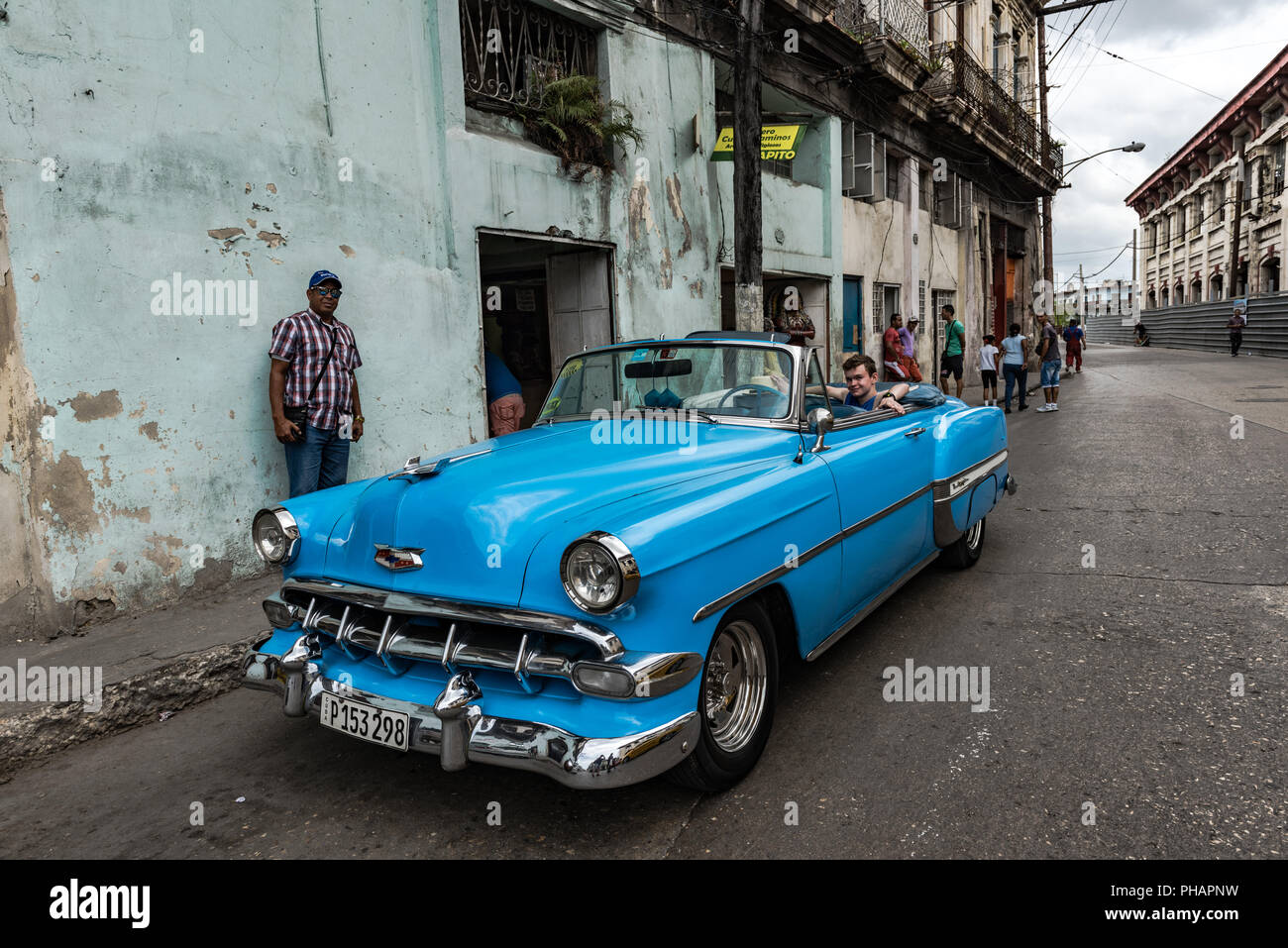Young tourist sitting in back seat of classic car on tour of Old Havana, Cuba. Stock Photo