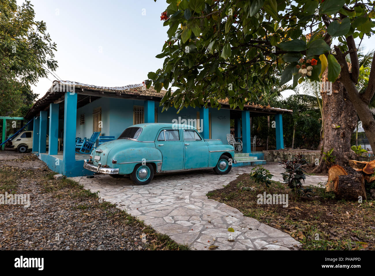 Vintage blue car in front of typical Cuban house in Trinidad, Cuba. Stock Photo