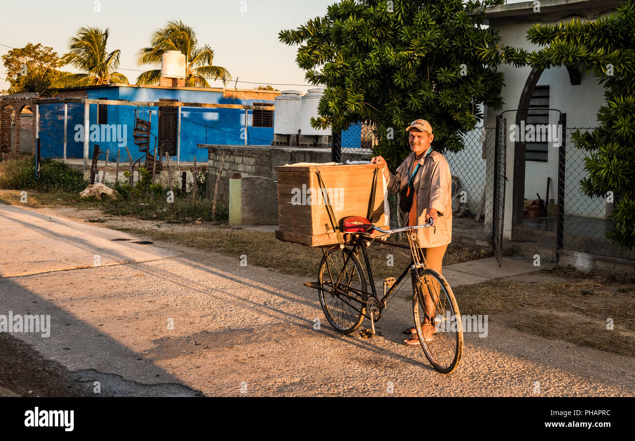 La Boca, Cuba - March 15, 2016: Cuban man delivers bread every morning in the rural town of La Boca using a bicycle equipped with a storage box. Stock Photo