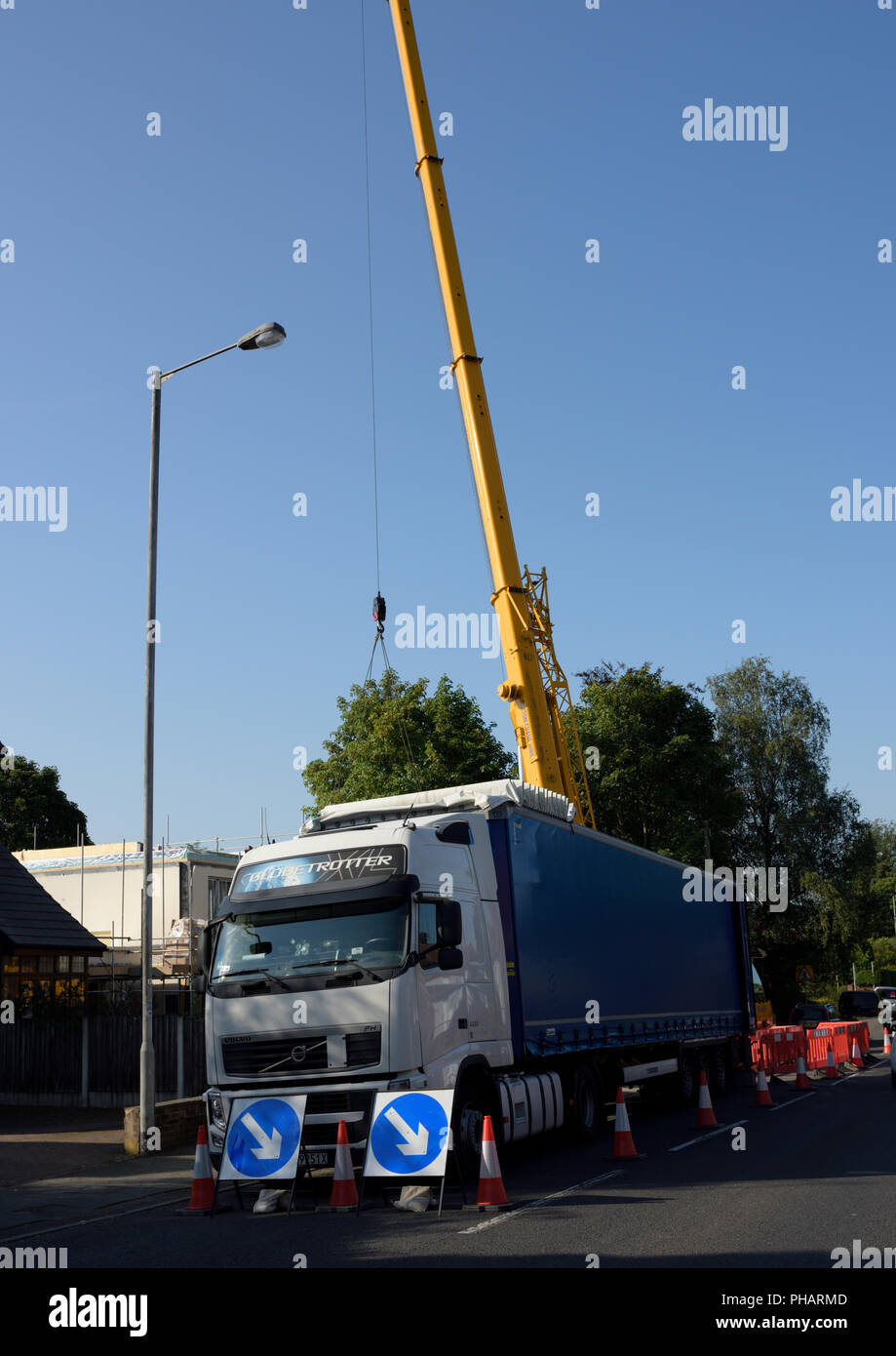 Elevated Hydraulic boom behind articulated lorry parked on street in