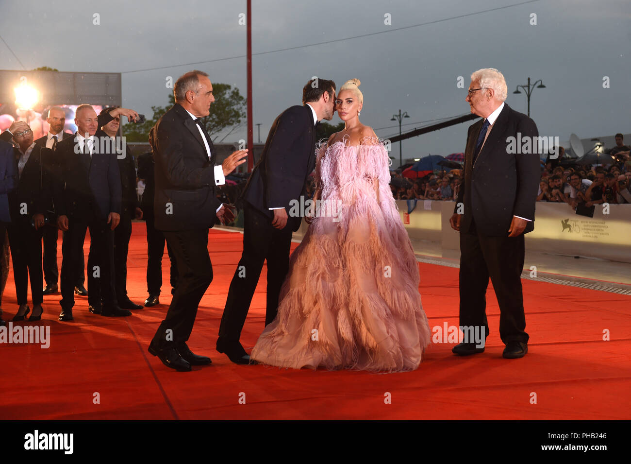 Venice, Italy. 31st Aug, 2018. The singer Lady Gaga and the actor and director Bradley Cooper (3-R) cross the red carpet at the world premiere of the film musical "A Star is Born" at the Venice Film Festival (other characters not identified). The film festival runs from 29 August to 8 September and is taking place for the 75th time this year. Credit: Felix Hörhager/dpa/Alamy Live News Stock Photo