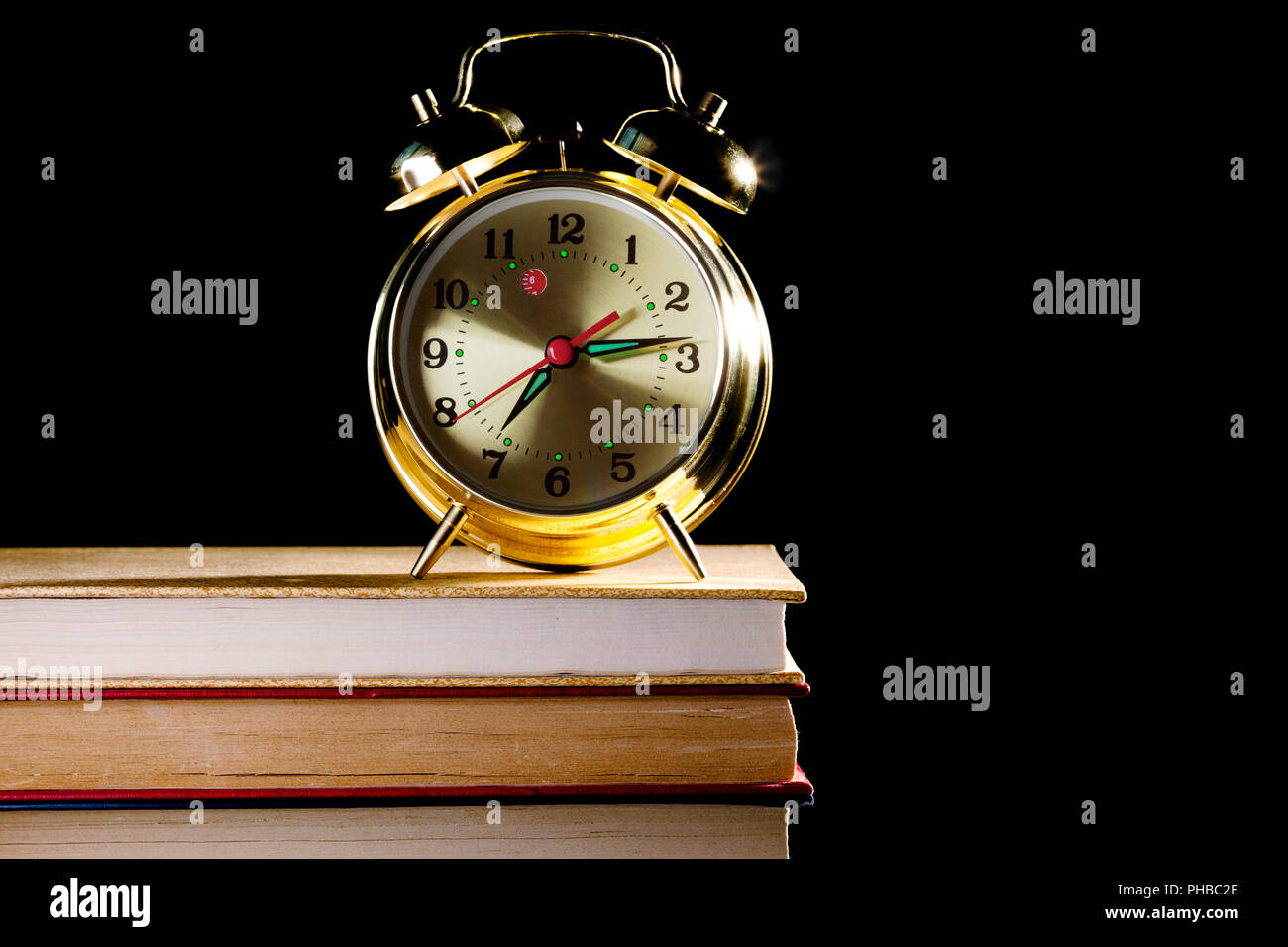 alarm clock standing on books Stock Photo