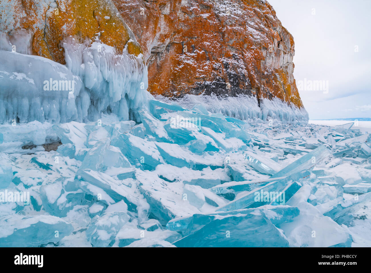 Blue frozen water covered with snow and icicles Stock Photo