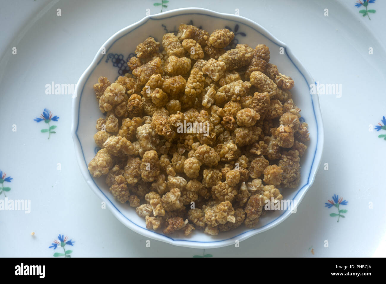 Dried mulberries in a Meissen bowl Stock Photo