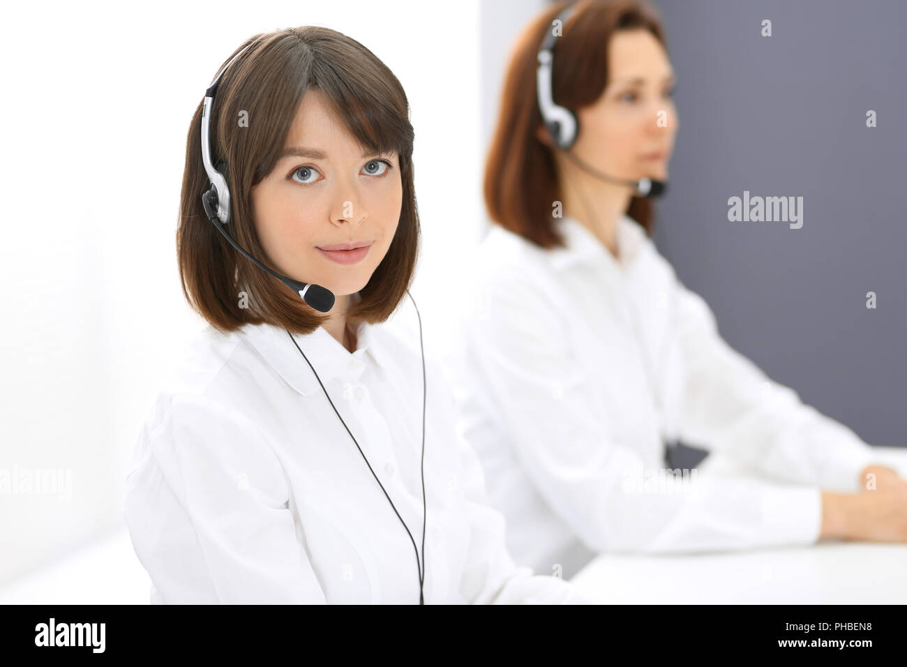 Call center. Group of operators at work. Focus on young woman