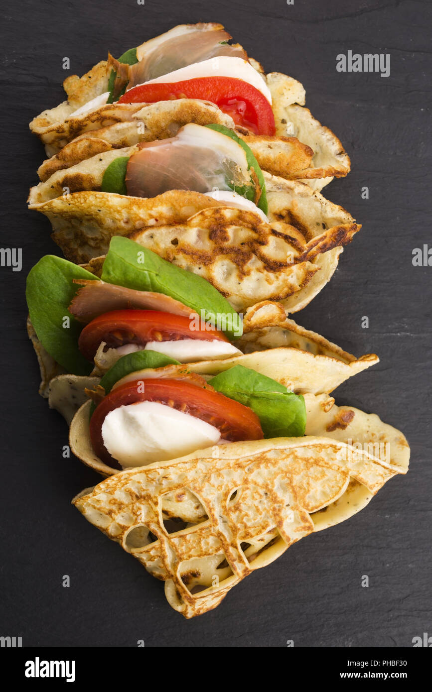 Pancakes sutffed with ham, cheese, tomatoes and spinach Stock Photo