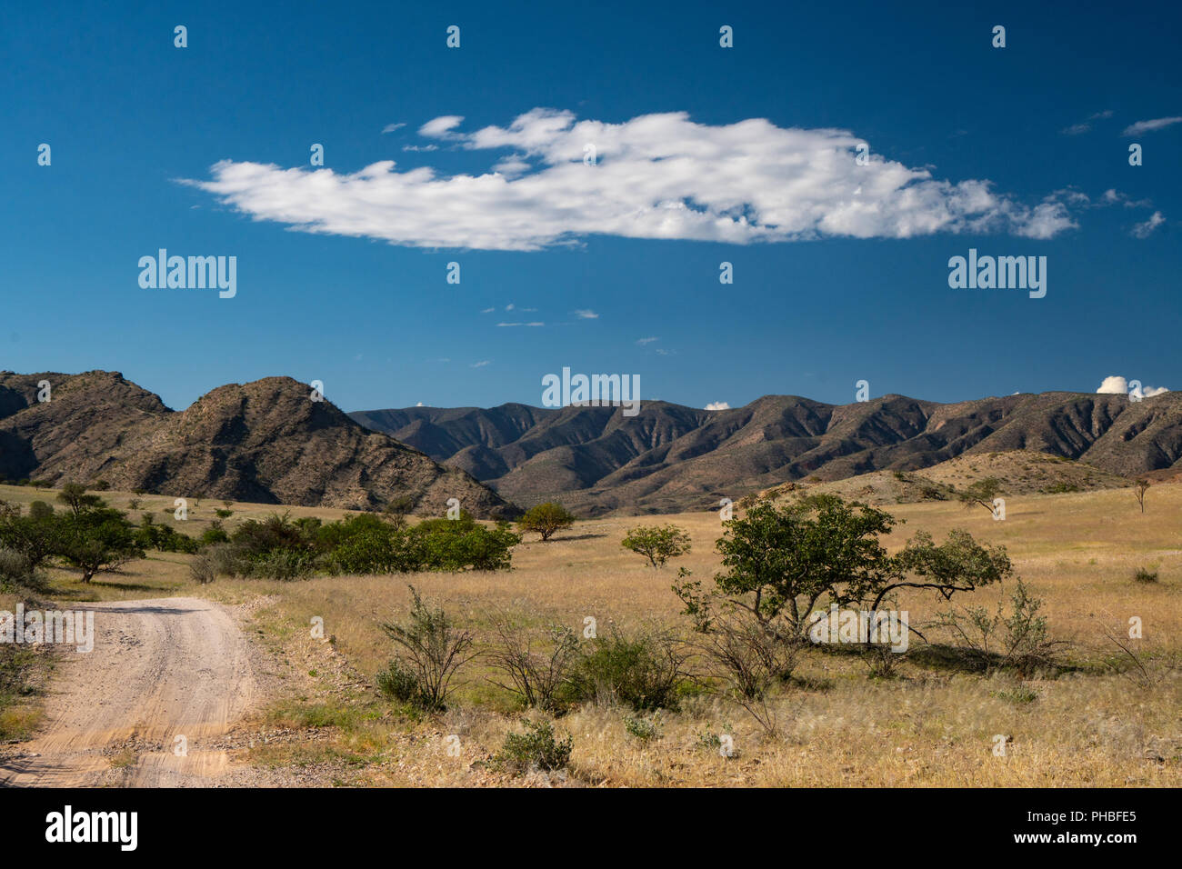 Dramatic cloud over green and mountainous landscape, north of Sesfontein, Namibia, Africa Stock Photo