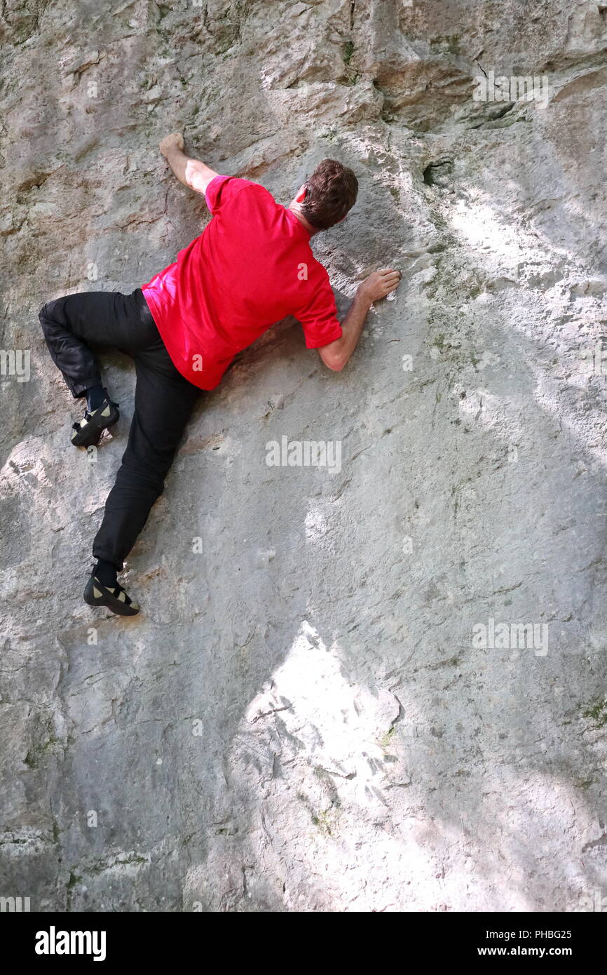 caucasian man is climbing on a rock wall Stock Photo