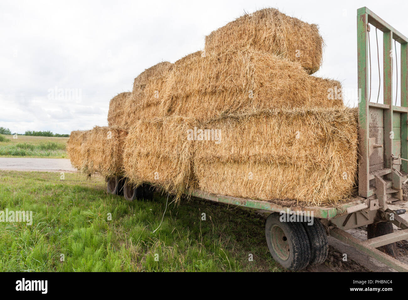 folded on a broken trailer, the wheel fell off, stacks of yellow straw