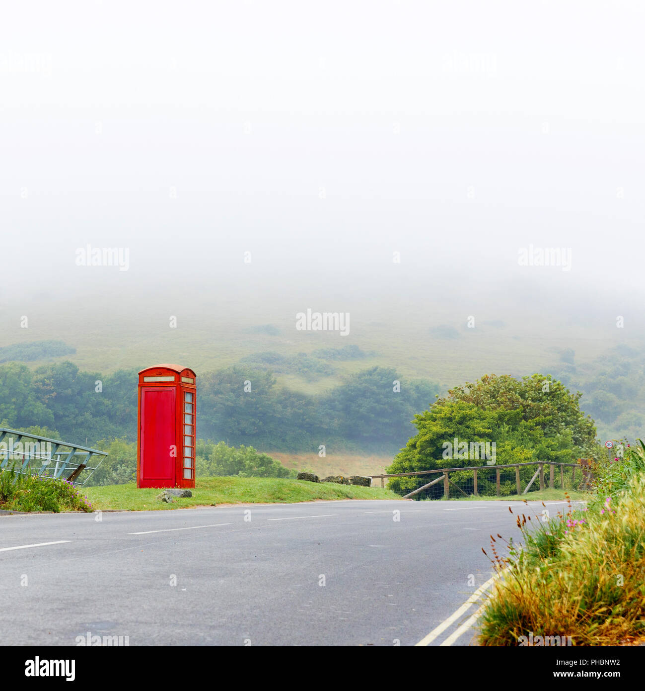 Fog with classical red telephone booth box in misty English countryside, United Kingdom Stock Photo