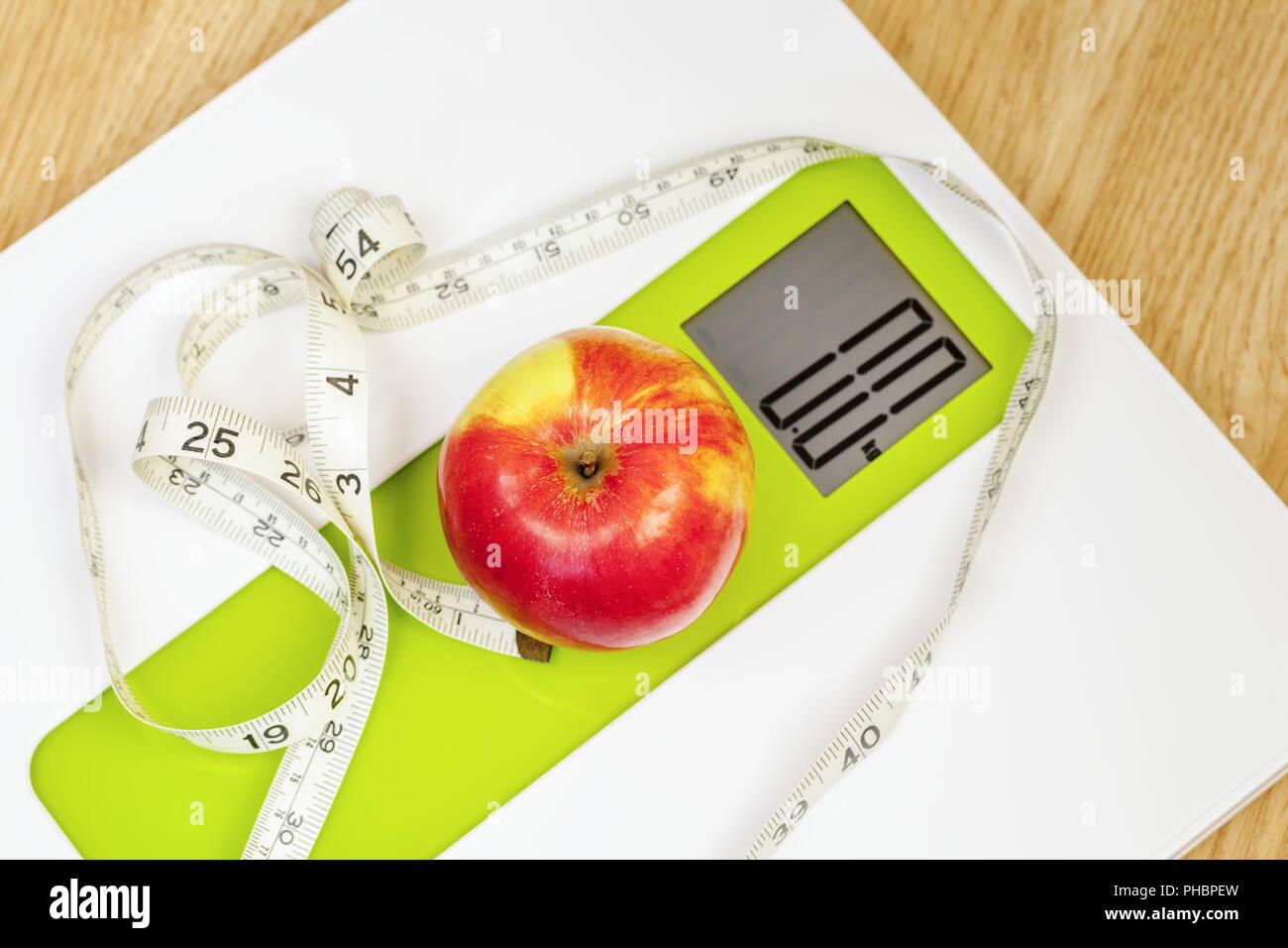 Apple with measuring tape close up on digital scale Stock Photo