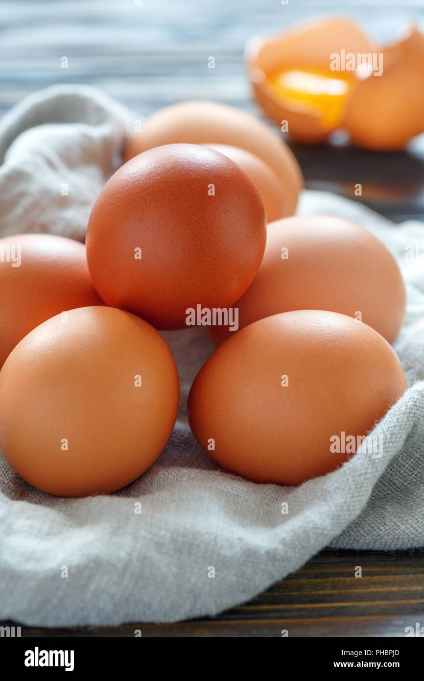 Chicken eggs and broken eggshell with the yolk. Stock Photo
