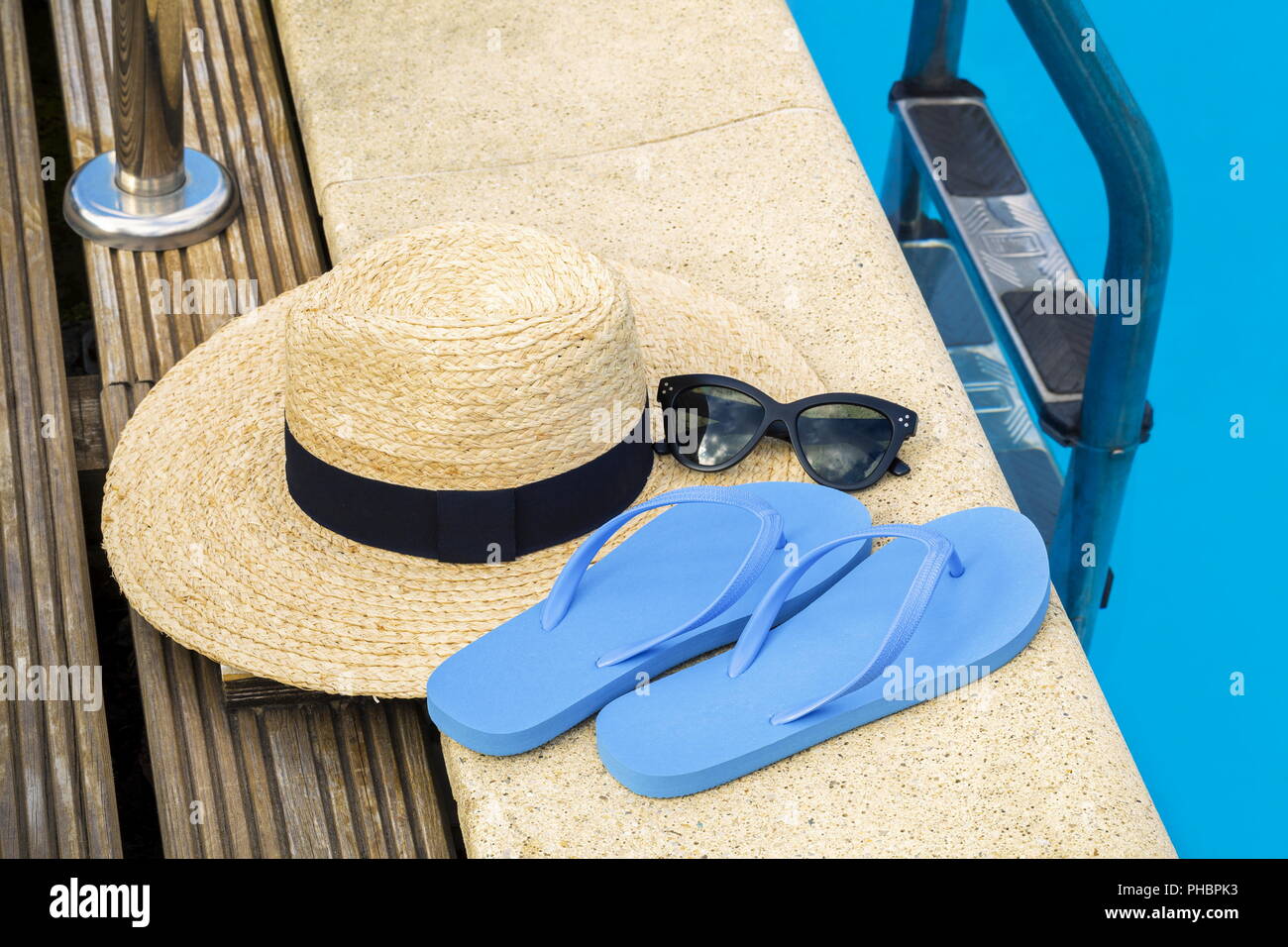 Straw hat with flip flops and sunglasses near swimming pool Stock Photo ...