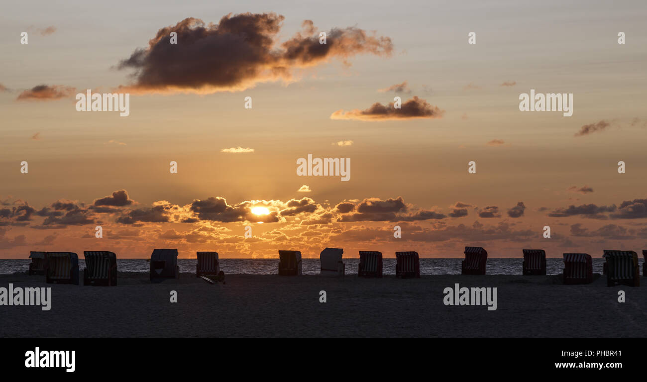sunset with beach chairs on Amrum, Germany Stock Photo