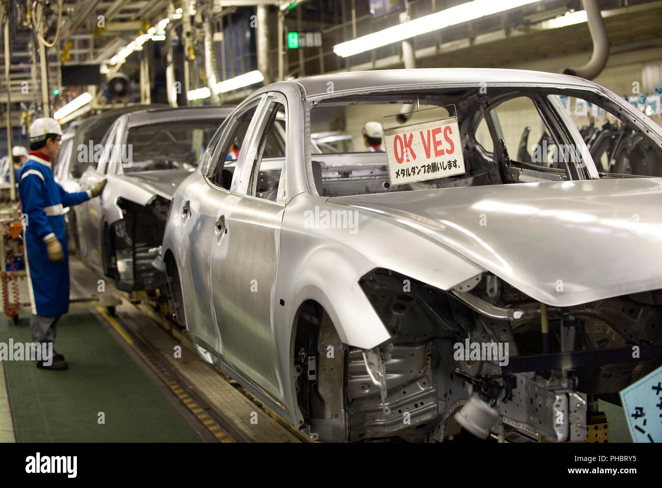 A worker checks for faults in the body of a vehicle at Nissan Motor Co.s body plant in Tochigi, Japan on Thursday 12 Nov.  2009.  Photographer: Robert Stock Photo