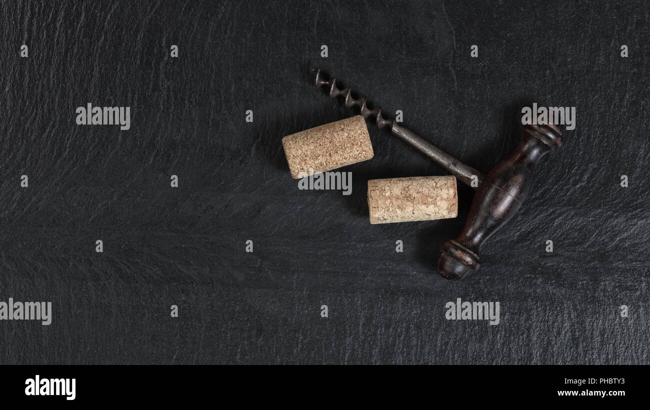 Overhead view of vintage corkscrew on black slate background Stock Photo