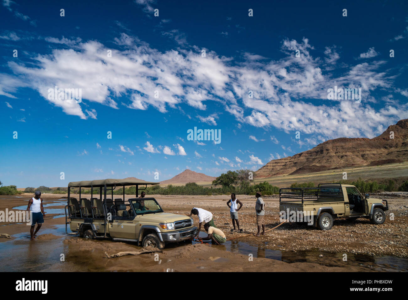 Rescuing safari vehicle stuck in sand of Hoarusib Riverbed, mountain range in background, Puros, north of Sesfontein, Namibia, Africa Stock Photo