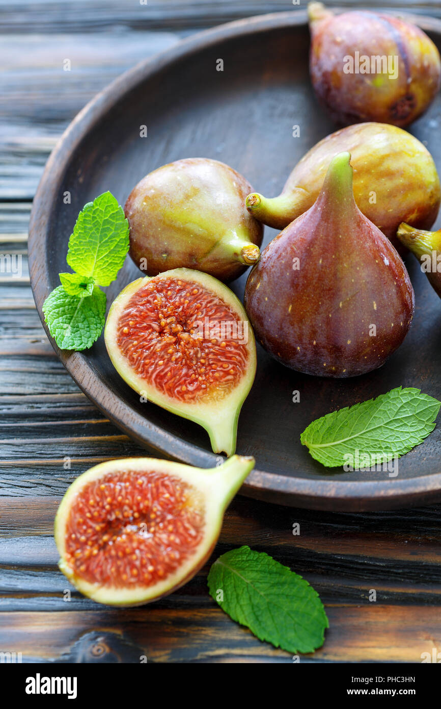 Fresh figs and mint leaves on a wooden platter Stock Photo Alamy
