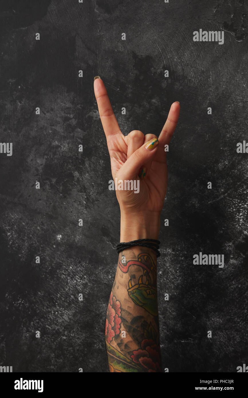 Female hand with tattoos showing two fingers Stock Photo