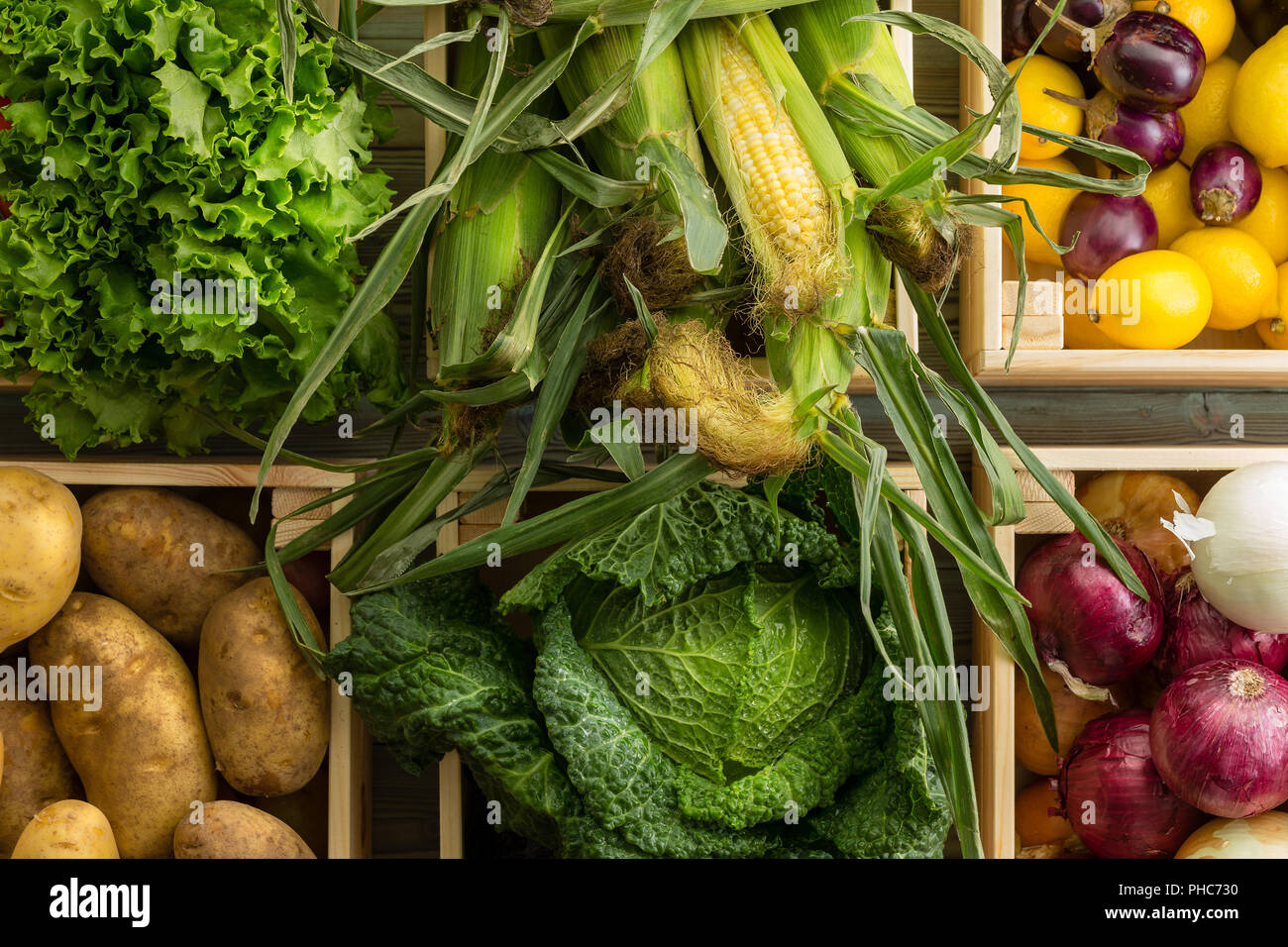 Assortment of healthy fresh raw vegetables and fruit in a wooden boxes at an organic farmers market viewed close up from above in a full frame food ba Stock Photo