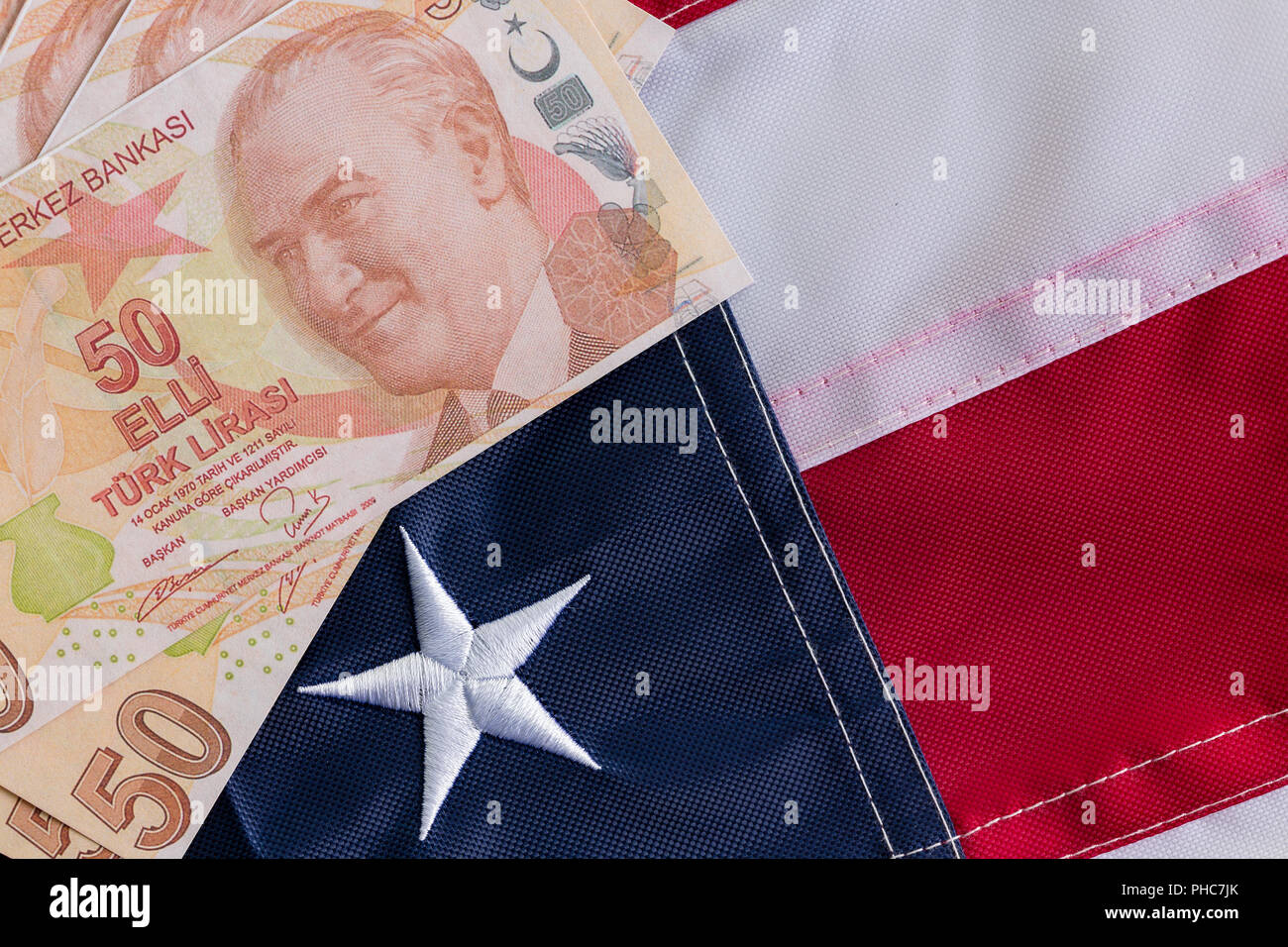 Turkish lira banknotes on a United States flag in a conceptual image of politics and currency devaluation in emerging markets in a closeup full frame  Stock Photo