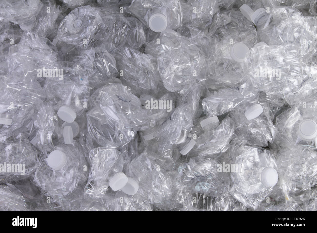 Background texture of crumpled crushed clear plastic bottles piled in a heap ready for recycling to save the environment Stock Photo
