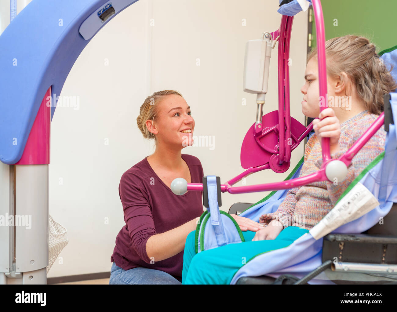 A disabled child being cared for by a special needs carer Stock Photo