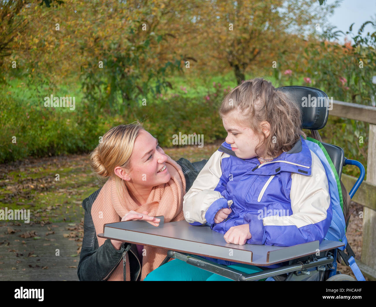 A disabled child being cared for by a special needs carer Stock Photo