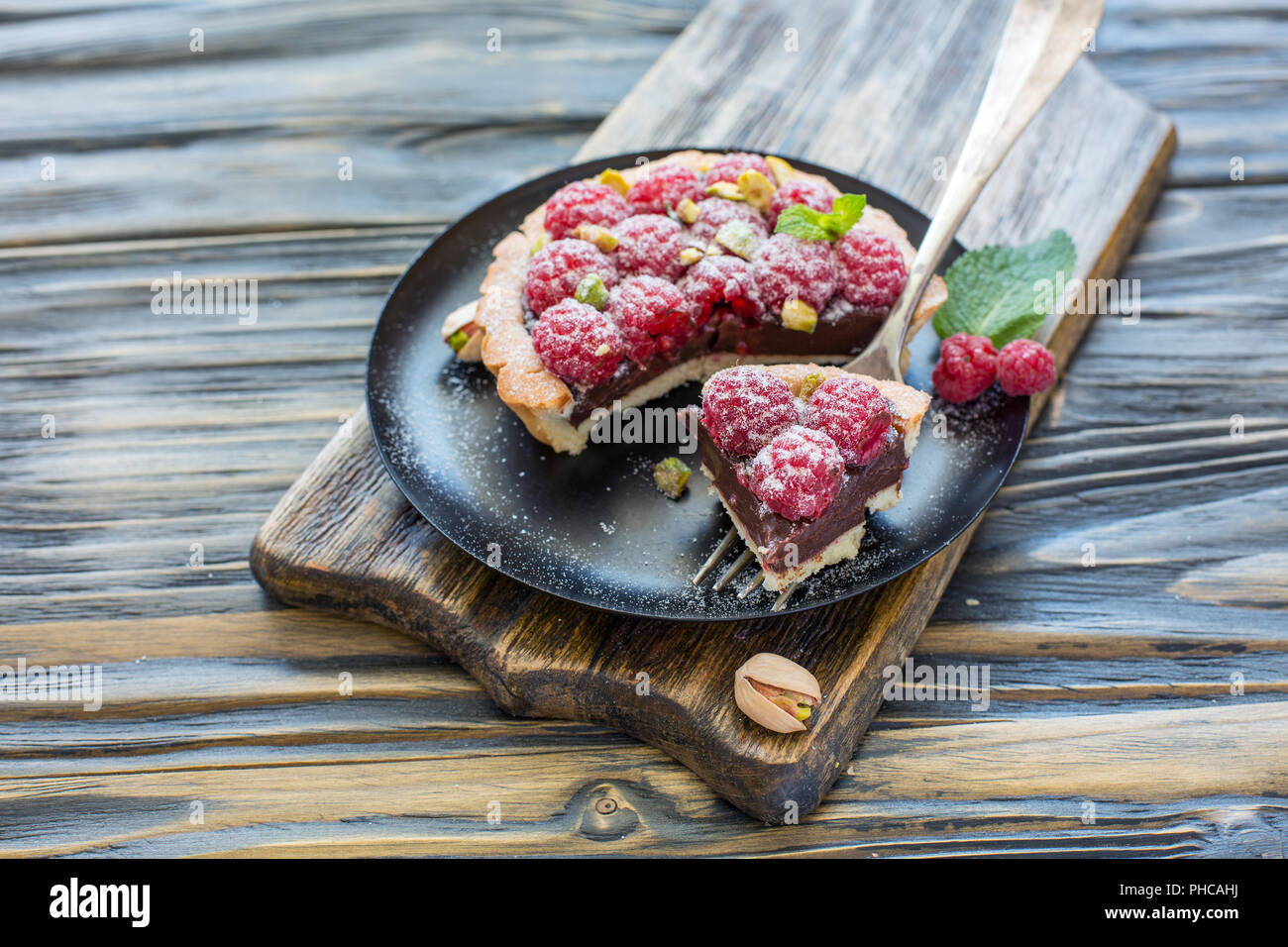 Chunk tartlets with raspberries on a silver fork. Stock Photo