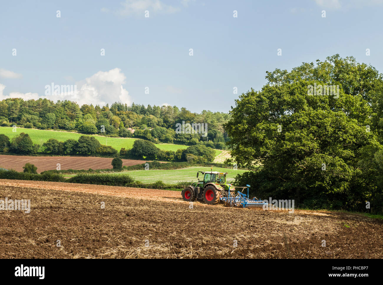 Farm Tractor harrowing a field near Trellech in Monmouthshire Stock