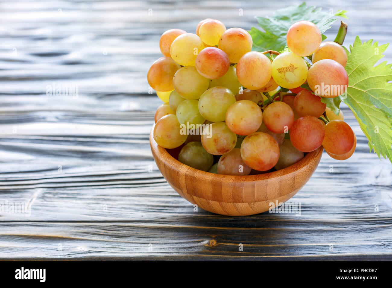 Bunch of pink grapes in a wooden bowl Stock Photo - Alamy