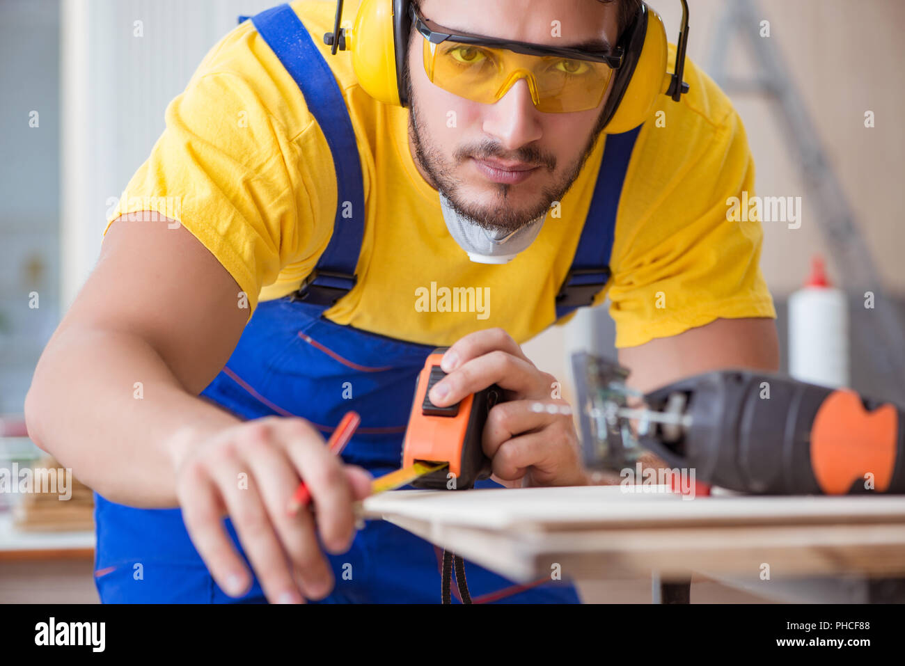 Young repairman carpenter working cutting wood on circular saw Stock