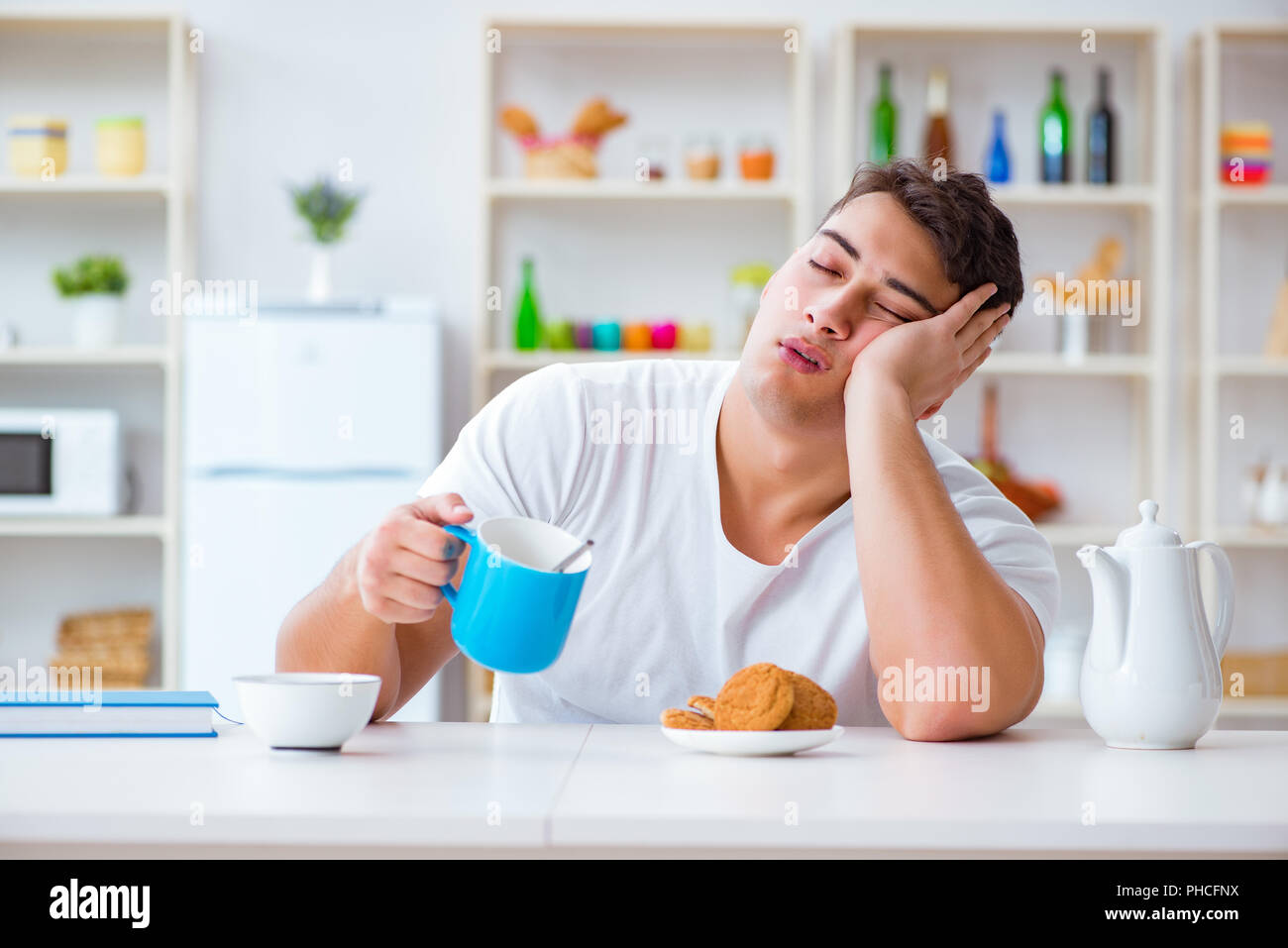 Man Falling Asleep During His Breakfast After Overtime Work Stock Photo