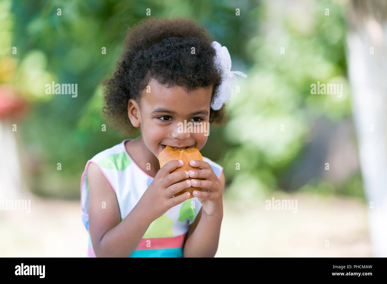 A beautiful 4 year old african american girl holding a two handed patty a