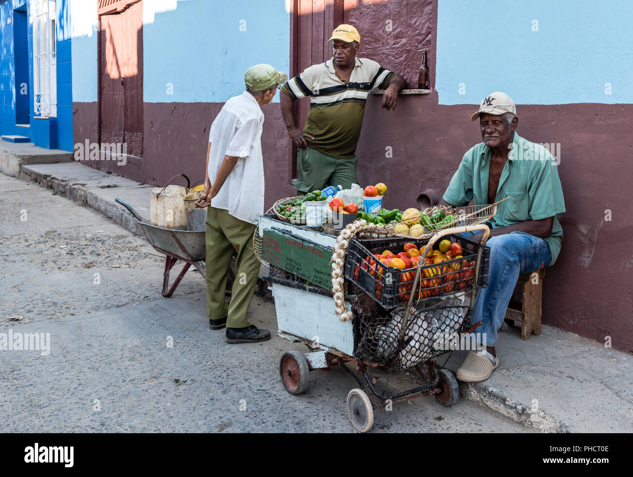 Business is slow. There's a fruit and vegetable cart set on a corner in Trinidad, Cuba. Stock Photo