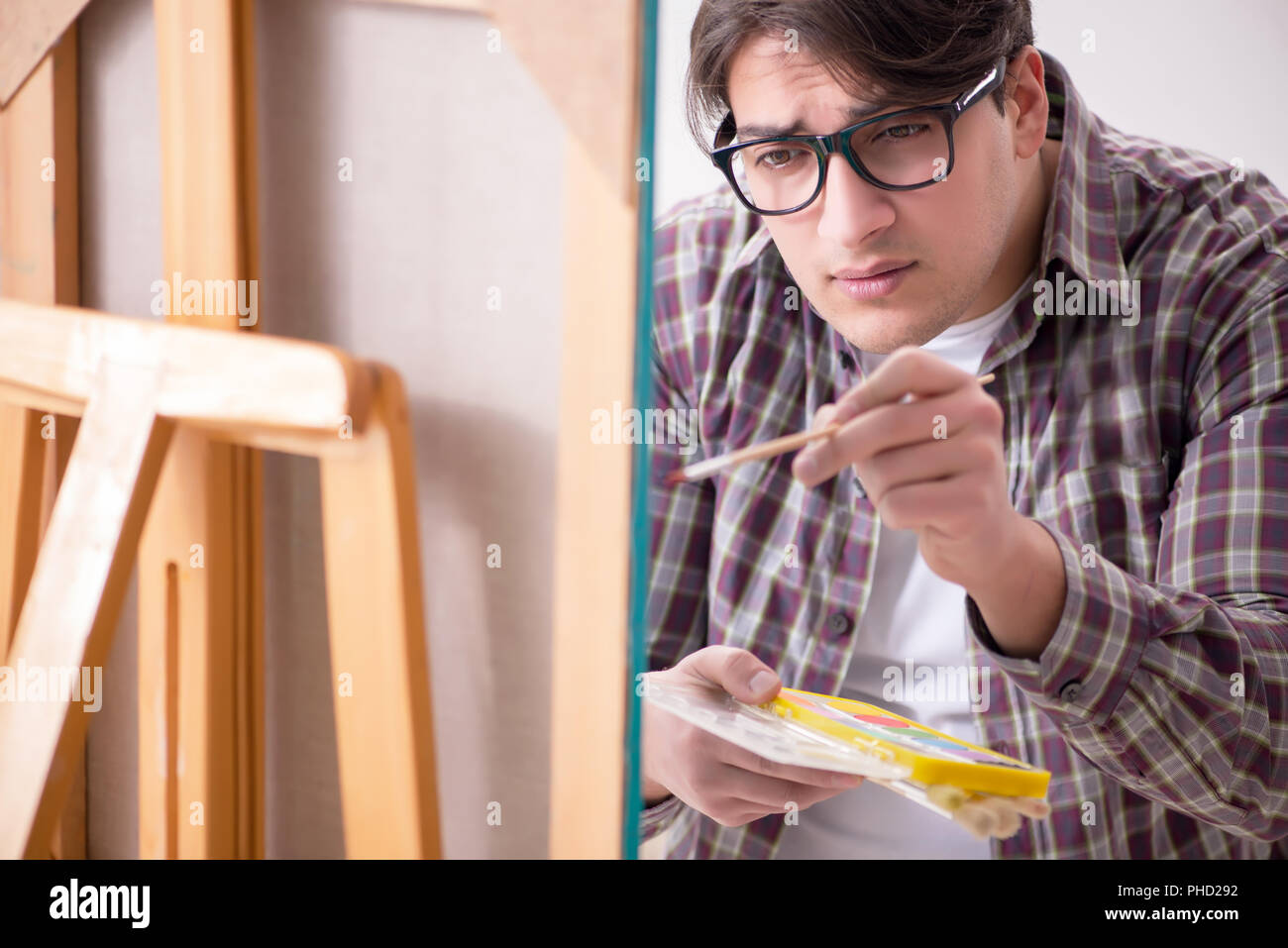 Young male artist drawing pictures in bright studio Stock Photo - Alamy