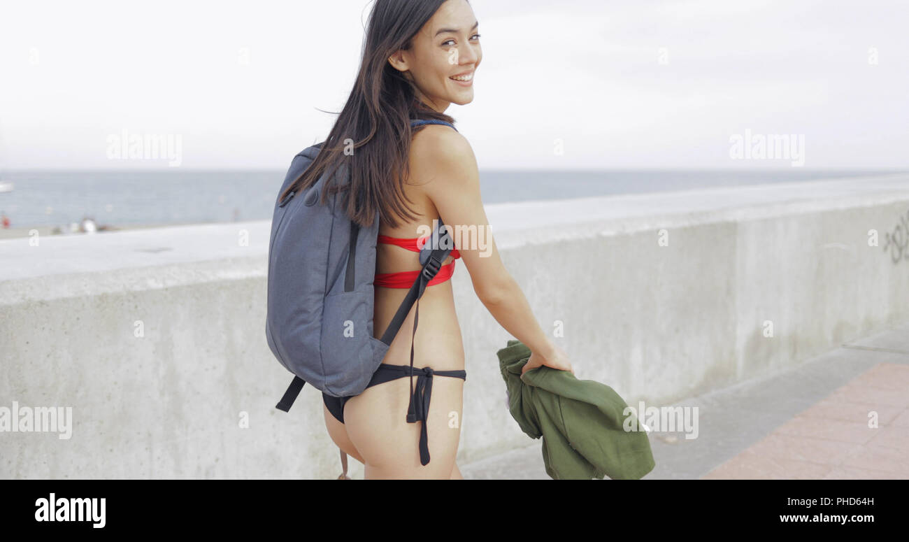 Content woman in bikini with backpack Stock Photo