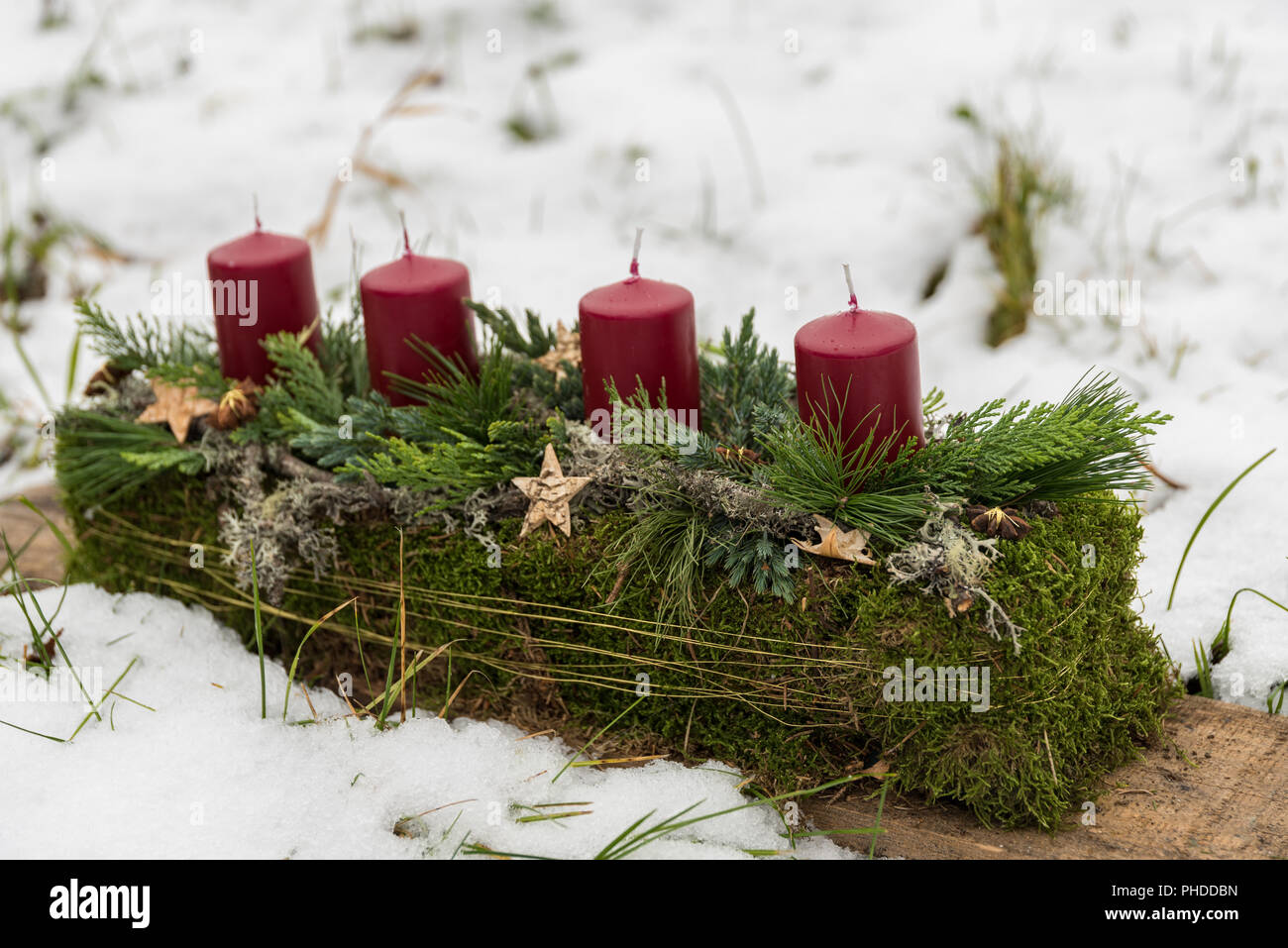 rustic Advent wreath in oblong shape stands in the snow Stock Photo