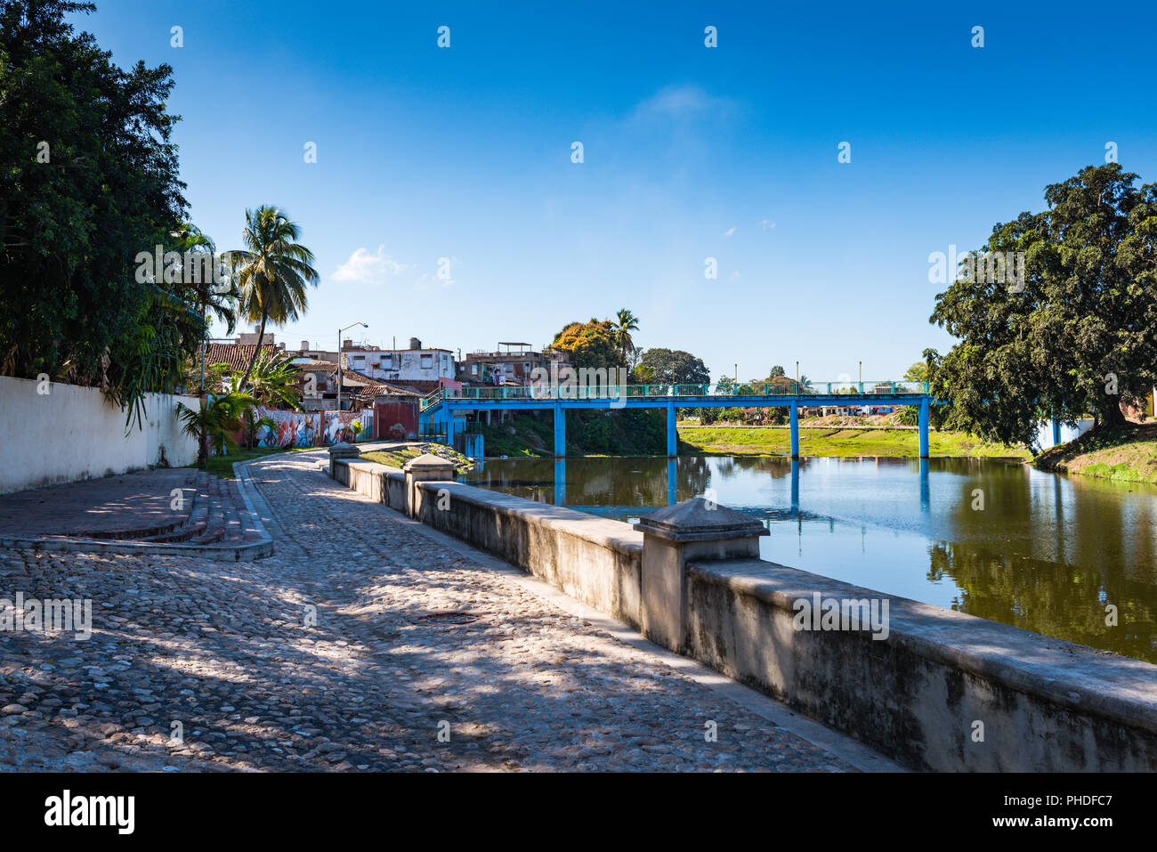 Sancti  Spiritus , Cuba / March 15, 2017:  Cobblestone walkway and mural along the Yayabo River. Stock Photo