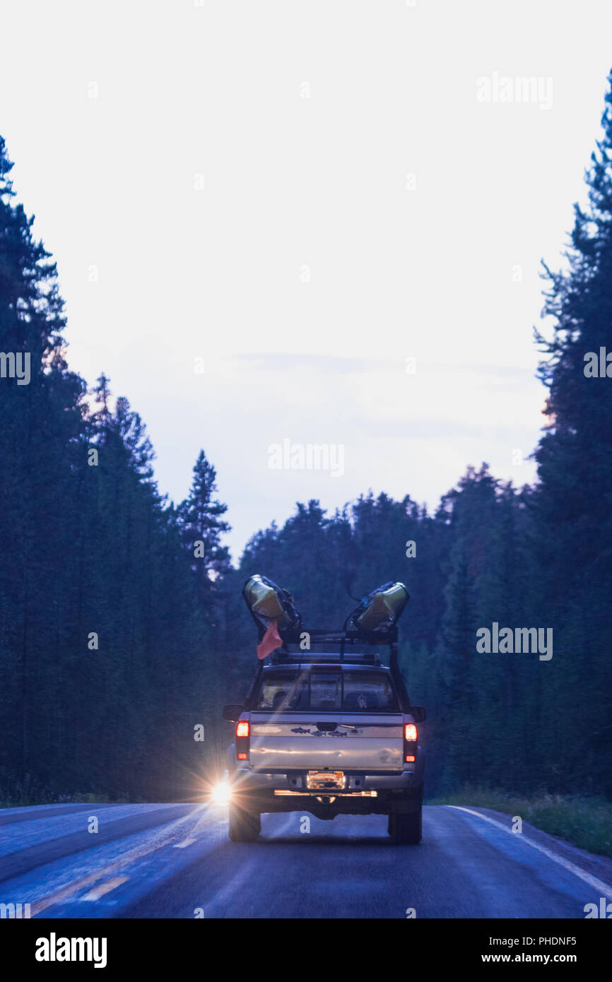 Truck on the road, transporting kayaks at dusk in the Yellowstone National Park Stock Photo