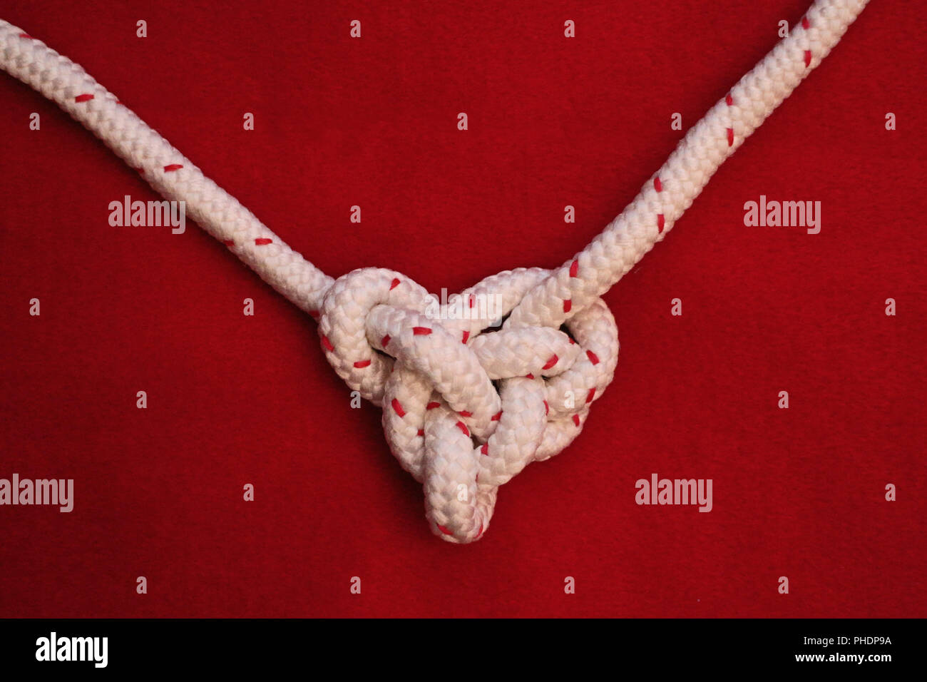 White rope knot on red background Stock Photo