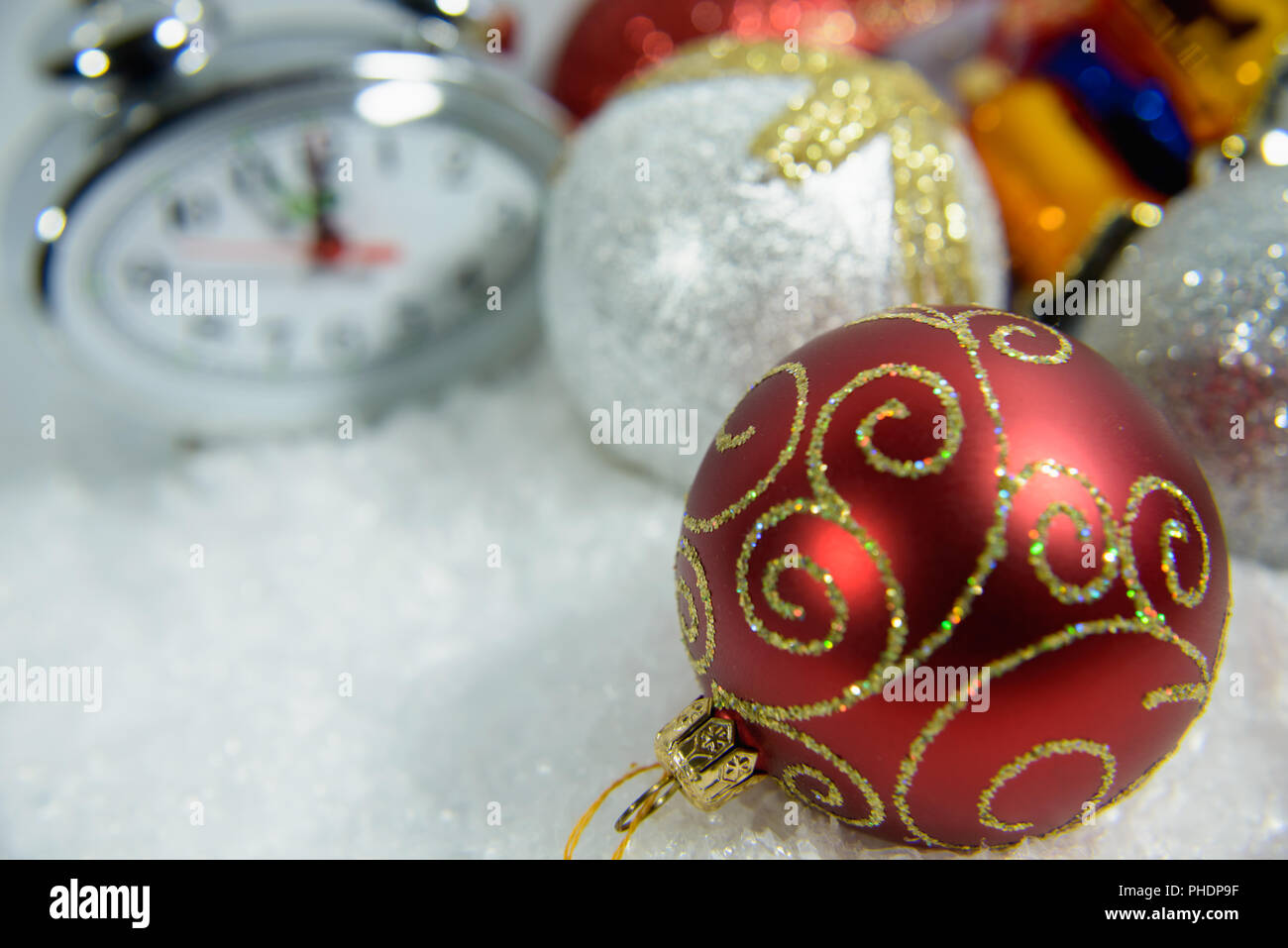 New Year Clock lie in brightly colored shiny tinsel Stock Photo