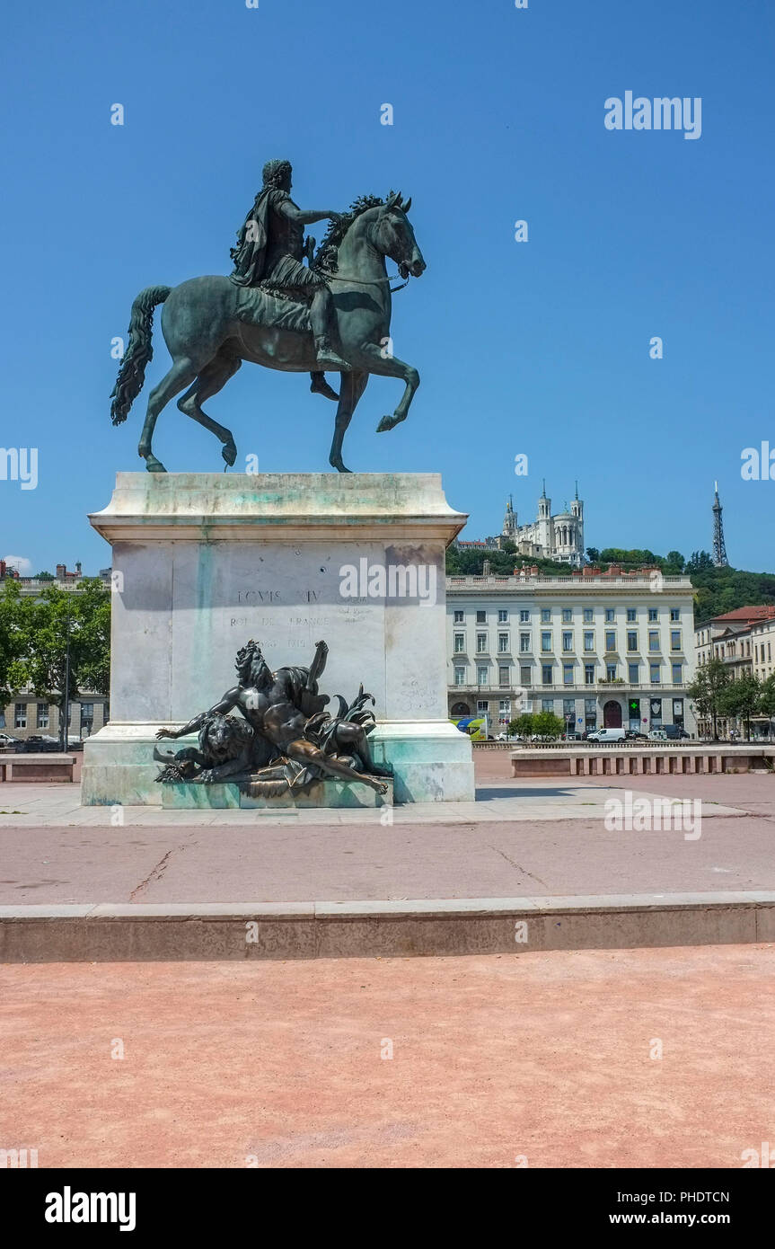 Equestrian statue of Louis XIV on the Place Bellecour with the Basilica of Notre-Dame de Fourvière in the background on the hill, in Lyon France. Stock Photo