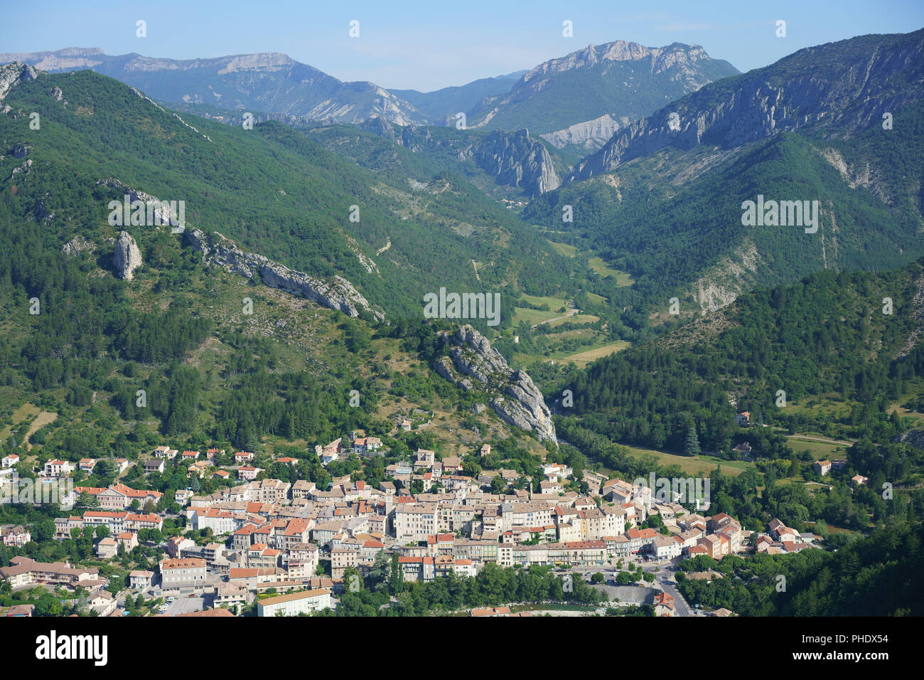 AERIAL VIEW. Picturesque medieval village in an unspoiled setting of forest and mountains in the Buëch Valley. Serres, Hautes-Alpes, Provence, France. Stock Photo