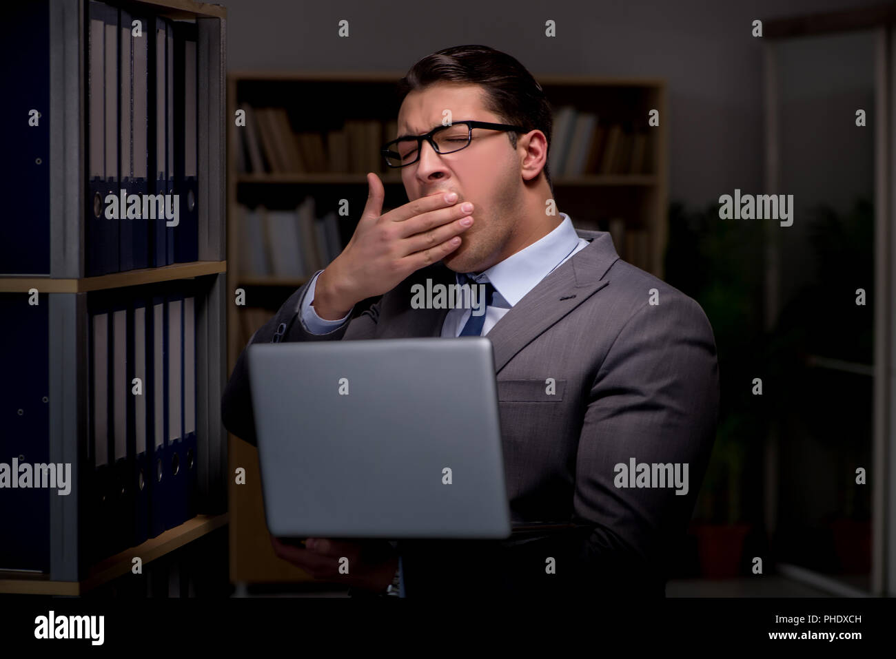 Businessman almost falling asleep working late hours in the offi Stock ...