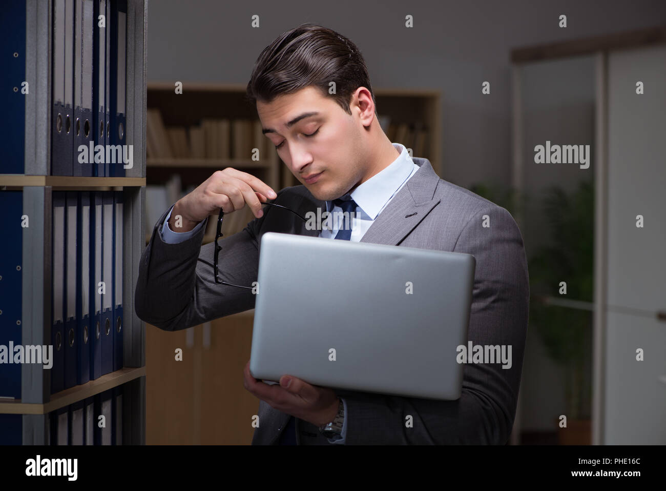 Businessman almost falling asleep working late hours in the offi Stock ...