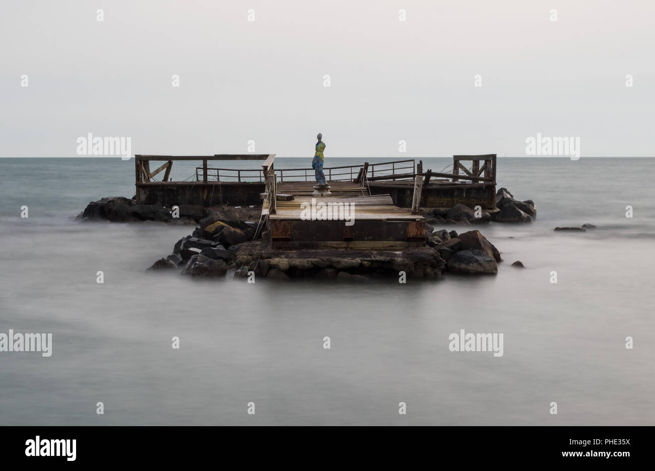 Ostia (Rome, Italy) - An old wooden pier on the sea, with statue Stock Photo